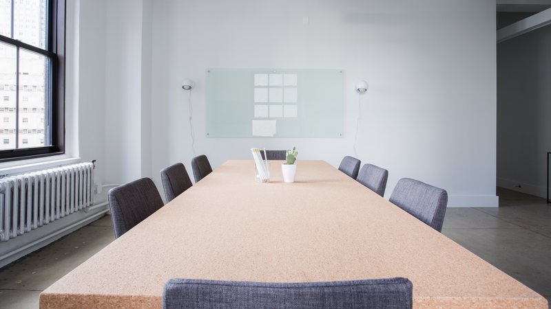 An empty conference room with a long table and chairs