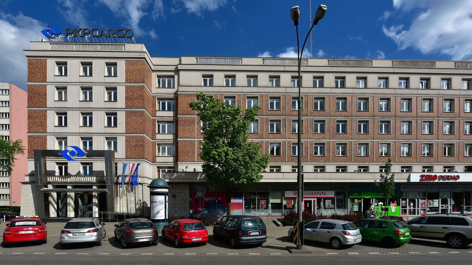 A modern office block with a PKP Cargo sign on a city street